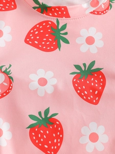 Close-up of pink cotton fabric with strawberry and flower print for girls' pajamas