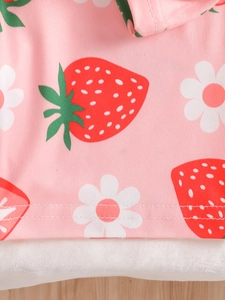 Close-up of pink children's pajamas featuring strawberry print and fine stitching detail