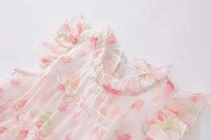 Detailansicht des Blumenmusters und Rüschenkragens am rosa Sommerkleid für Mädchen