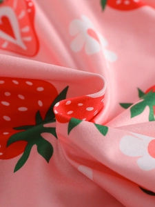 Pink girls' summer pajamas with strawberry and flower prints on soft fabric texture