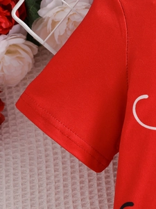 Close-up of double-needle stitching on red cotton sleeve with ladybug print detail