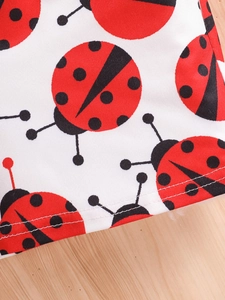 Close-up of ladybug print fabric with detailed double-stitched hem on summer outfit