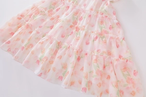 Detail eines gestuften Chiffon-Rocks mit rosa-orangem Tulpendruck für Mädchen