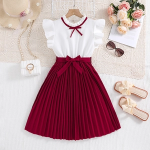 Flat lay of girl's summer dress with white top, red pleated skirt, and accessories