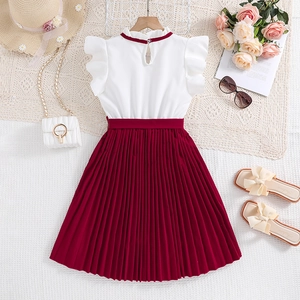 Flat lay of a girls red pleated dress with white ruffled sleeves and straw hat decor
