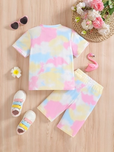 Ensemble d'été fille tie-dye avec t-shirt cygne et short sur fond en bois clair