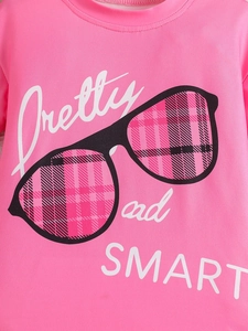 Detail of pink cotton T-shirt with Pretty and SMART sunglasses print and plaid pattern