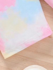 Détail du tissu tie-dye pastel avec coutures renforcées et texture en coton doux