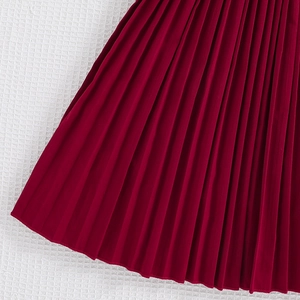 Detailed macro view of dense pleated texture on deep red girls princess maxi dress