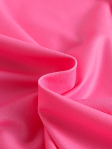 Detailed close-up of bright pink knitted fabric with horizontal texture for kids swimwear