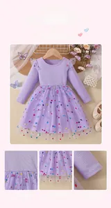 Detail of purple long-sleeved dress showing polka dot mesh layers and bow decoration