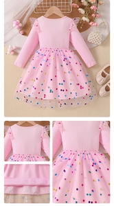 Detail of pink long-sleeve girl dress showing sequin tulle skirt and ribbed texture