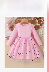 Detail of pink long sleeve dress with colorful polka dot sequins on layered mesh skirt