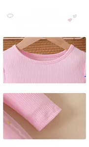 Detail of pink ribbed knit dress showing the round neckline and elastic ruffled cuffs