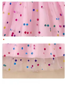 Detailed view of pink mesh fabric with colorful polka dots and tiered skirt layers