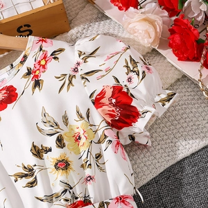 Close-up of floral girls dress showing puff sleeves and elegant red flower patterns