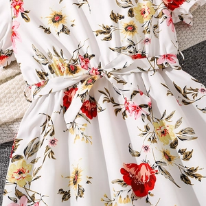 Close-up of floral summer dress with tie-waist bow and vibrant flower print pattern