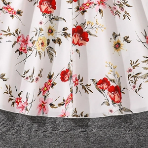 Close-up of floral print fabric on a white girl's dress with pink and yellow flowers