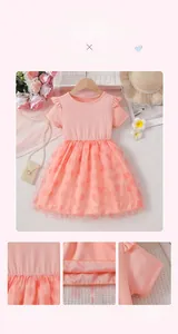 Detail of pink toddler dress featuring ruffled shoulders and heart-patterned tulle skirt