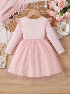 Pink long sleeve girl's dress with gold star sequin mesh skirt on a wooden background