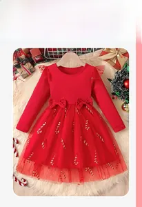 Detail of red Christmas girls dress featuring candy cane mesh skirt and velvet bows