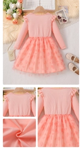 Detail of pink long sleeve dress featuring knit top and mesh heart print skirt