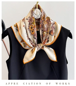 Detail of silk wool butterfly scarf with orange hand-rolled edges and camellia brooch