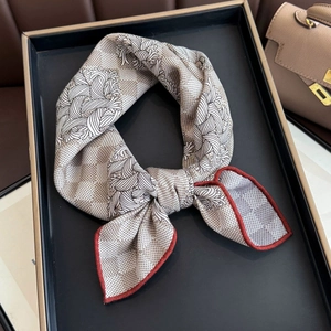 Luxury silk wool square scarf with floral print and rolled edges on a display tray