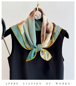 Detail of silk scarf with floral print and yellow piping tied on a black dress