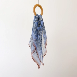 Detailed view of light blue paisley chiffon scarf draped through a wooden ring