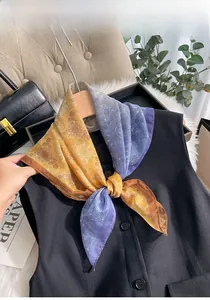 Détail d'un foulard en soie élégant avec imprimé cachemire jaune et bleu sur gilet