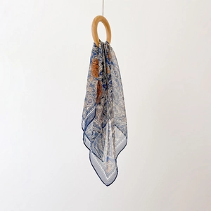 Gros plan sur la texture élégante d'un foulard en soie à motif Paisley drapé sur un anneau