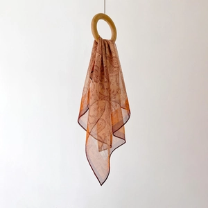 Lightweight paisley chiffon neck scarf in brick red with elegant wooden ring hanging