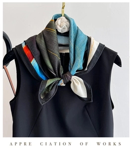 Detail of silk wool square scarf with abstract pattern and white camellia brooch