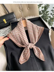 Détail d'un foulard en mousseline marron à pois de 70x70cm noué sur une veste noire