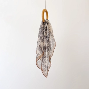 Détail d'un foulard en mousseline de soie à imprimé floral vintage avec anneau bois