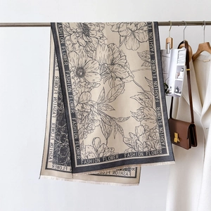 Detail of floral printed scarf with Fashion Flower text border and tassel edges