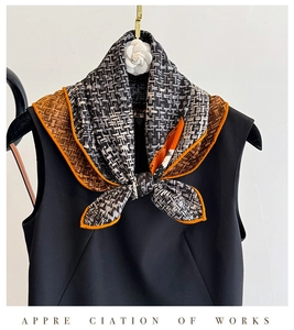 Detail of silk wool scarf showing geometric patterns and orange hand-rolled edges