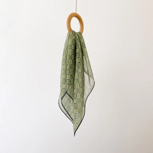 Vintage green floral chiffon square scarf hanging from a natural wooden ring