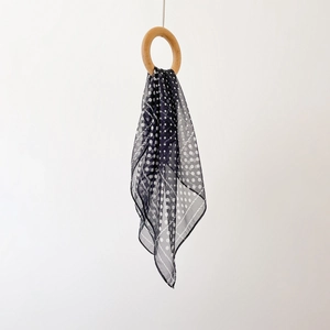 Detail of navy blue polka dot chiffon square scarf with rope border and sheer texture