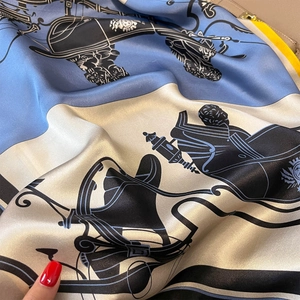 Elegant silk scarf featuring carriage patterns with blue and cream contrast border