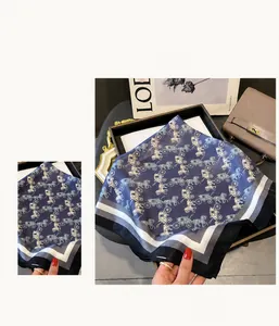 Macro detail of silk scarf featuring dark blue carriage pattern and striped edges