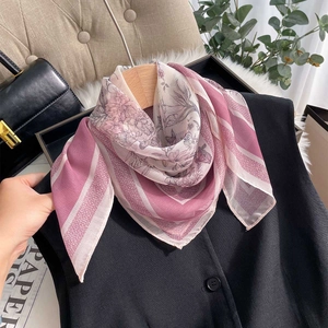 Close-up of floral chiffon neckerchief tied on a black vest against a stylish background