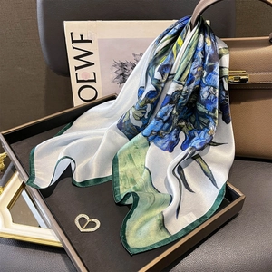 Carré en soie aux motifs d'iris avec broche cœur dorée sur un sac à main chic