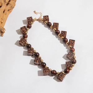 Detail of bohemian necklace with leopard resin cubes, wood beads and gold lobster clasp