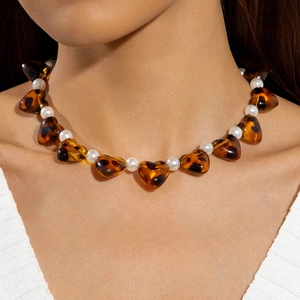 Irregular tortoise shell heart pendant necklace with white pearls on female model