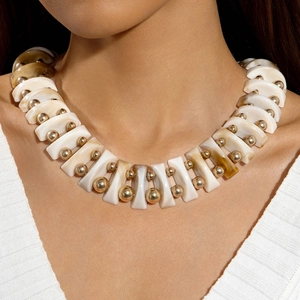 Detail of elegant marble texture bow beads and gold metallic spheres on a unique necklace