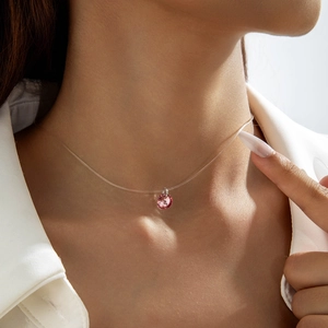 Gros plan d'un collier en fil de nylon invisible avec pendentif en cristal rose rond