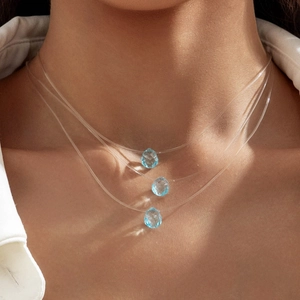 Vue détaillée du collier invisible triple épaisseur avec cristaux bleus en goutte