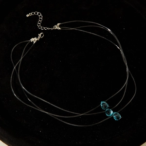 Vue détaillée du collier invisible triple épaisseur avec trois gouttes en cristal bleu